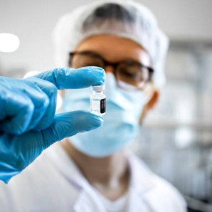 Pharmaceutical worker or technologist in protective equipment controlling quality of sample.png